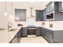 Beautiful kitchen with stainless steel appliances, light countertops, and dark blue cabinets at 2744 Bear Springs Cir, Longmont, CO 80503