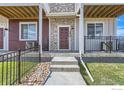 Inviting townhome entry with a stone facade and well-maintained landscaping at 2770 Bear Springs Cir, Longmont, CO 80503
