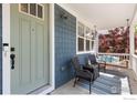 Cozy front porch with a swing, seating, and a charming entrance at 2856 Shadow Lake Rd, Lafayette, CO 80026