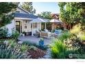 Relaxing patio with comfortable seating, umbrellas, and a fire pit surrounded by lush landscaping at 2942 4Th St, Boulder, CO 80304