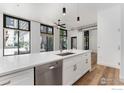 Modern kitchen with stainless steel appliances, sleek countertops and large windows at 3100 Huron St # 1D, Denver, CO 80202