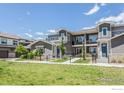 Inviting townhouse featuring a neatly kept lawn, sidewalk, and charming architectural details at 330 High Point Dr # 104, Longmont, CO 80504