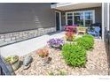 Charming outdoor patio with vibrant flowers, colorful seating, and attractive landscaping at 330 High Point Dr # 104, Longmont, CO 80504