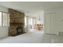 Bright living room with a stone fireplace, natural light, and an adjacent dining area at 3345 Chisholm Trl # 206, Boulder, CO 80301
