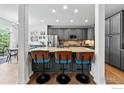 Kitchen island featuring granite countertops, seating, gray cabinets, stainless steel appliances, and recessed lighting at 4915 Sage Brush Dr, Broomfield, CO 80023