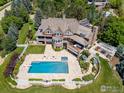Stunning aerial view of a luxury home with a beautiful pool, patio, and manicured landscaping at 6487 Cherry Ct, Niwot, CO 80503