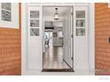 Inviting entryway featuring hardwood floors, stylish lighting, and an open doorway at 6487 Cherry Ct, Niwot, CO 80503