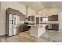 Spacious kitchen with stainless steel appliances, a large island, and dark cabinets at 11129 Paradise Ln, Firestone, CO 80504