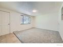 Bright living room with neutral carpet, a window, and a white painted door at 131 E 15Th Ave, Longmont, CO 80504
