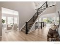 Bright entryway with staircase, light hardwood floors, and views into living and dining areas at 1389 Lyons Ln, Erie, CO 80516