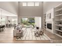 Bright living room with vaulted ceilings, fireplace, built-in shelves, and patio access at 1389 Lyons Ln, Erie, CO 80516