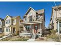 Inviting two-story home showcases a cozy front porch, complemented by a second-story balcony and neat landscaping at 1419 W 67Th Ave, Denver, CO 80221