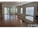 Bright living room featuring gleaming hardwood floors, plenty of natural light, and sliding glass doors at 1435 Rustic Dr, Longmont, CO 80504