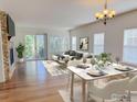 Bright living room with hardwood floors, fireplace, white sofa, and marble dining table with garden view at 1435 Rustic Dr, Longmont, CO 80504