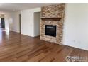 Cozy living area featuring a modern fireplace with stone surround and hardwood floors throughout at 1435 Rustic Dr, Longmont, CO 80504