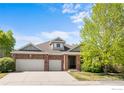 Charming two-story brick home with a two-car garage and a well-manicured lawn and mature landscaping at 1513 Cannon Mountain Dr, Longmont, CO 80503
