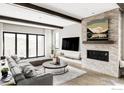 Modern living room with hardwood floors, fireplace, exposed beams, and large sliding glass doors at 15373 Irving Ct, Broomfield, CO 80023