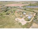 Wide aerial shot highlighting the acreage, pond, outbuildings, and overall property boundaries at 18247 County Road 22, Fort Lupton, CO 80621