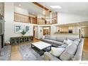 Spacious living room with a vaulted ceiling, brick fireplace, and an open layout to the kitchen at 1900 Eldorado Cir, Superior, CO 80027