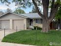 Cozy home with a large shade tree, well-kept lawn, and neutral brick at 1906 Yeager Dr, Longmont, CO 80501