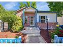 Charming home featuring brick accents, blue trim, landscaped yard, and a walkway leading to the front door at 3132 Concord Way, Longmont, CO 80503