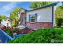 Charming home featuring brick accents, blue trim, landscaped yard, and a walkway leading to the front door at 3132 Concord Way, Longmont, CO 80503