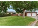 Charming single-story home with a lush green lawn and a two-car garage with mature trees at 3400 Erving Ct, Berthoud, CO 80513