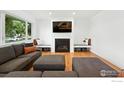 Cozy living room with fireplace, modern finishes, large window, and comfortable seating at 4545 Martin Dr, Boulder, CO 80305