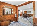 Inviting foyer with wood paneled wall, offering a warm welcome into the home with views of the dining area at 63 Sillasen Ln, Golden, CO 80403