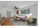 Bright and airy living room featuring a large window, wood floors, and a comfortable sofa at 6755 W 33Rd Ave, Wheat Ridge, CO 80033