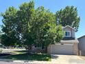 Charming two-story home with a well-maintained lawn and mature trees providing ample shade and curb appeal at 6924 Quigley Cir, Firestone, CO 80504