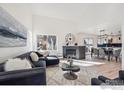 Bright living room featuring high ceilings, a modern fireplace, and large windows at 6924 Quigley Cir, Firestone, CO 80504