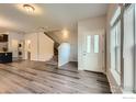 Open-concept living space featuring wood-look flooring, staircase access, and ample natural light at 876 Winding Brook Dr, Berthoud, CO 80513