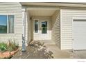 Inviting front entryway with a covered porch, light fixture, and direct garage access at 1226 Fremont Ct, Longmont, CO 80504