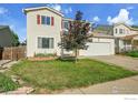 Traditional home with a manicured lawn, attached garage, and cozy feel at 1226 Fremont Ct, Longmont, CO 80504