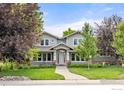 Charming home featuring a welcoming front porch, lush landscaping, and a well-maintained lawn at 1231 Hawk Ridge Rd, Lafayette, CO 80026