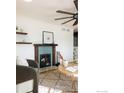 Charming fireplace with decorative mantel, complemented by stylish decor and a ceiling fan, enhancing the room's ambiance at 14117 W 58Th Pl, Arvada, CO 80004