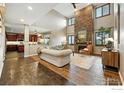 Bright living room boasts soaring ceilings, a stone fireplace, and wood-look tile floors at 15810 E Tall Timber Ln, Parker, CO 80134