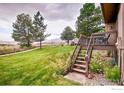 Lush backyard view from deck, features manicured lawn, lovely flowers, and mountain views in the distance at 1624 Bradley Ct, Boulder, CO 80305