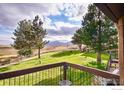 Scenic backyard view from balcony showcases lush lawn, mature trees, and picturesque mountain backdrop at 1624 Bradley Ct, Boulder, CO 80305