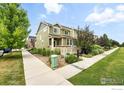 Inviting two-story home with beautiful landscaping, a walkway, and a lush green lawn at 173 Jackson Dr, Erie, CO 80516