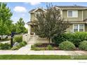 Beautiful two-story home featuring a charming white fence and lush landscaping at 173 Jackson Dr, Erie, CO 80516