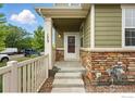Charming front porch with stone accents and a well-manicured yard at 173 Jackson Dr, Erie, CO 80516