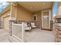 Cozy front porch with white chairs, stone accents, and a 'Welcome' mat at the front door at 17995 E 107Th Pl, Commerce City, CO 80022