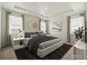 Bright main bedroom features a tray ceiling, neutral decor, carpet, and large windows with elegant curtains at 1842 Chaffee Crest Dr, Berthoud, CO 80513