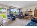 Inviting living room with a brick fireplace, views and comfortable seating arrangements at 2110 Charro Ave, Longmont, CO 80504