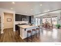 Spacious kitchen with dark cabinets, a large center island with seating, stainless steel appliances, and eat-in dining area at 286 Western Sky Cir, Longmont, CO 80501