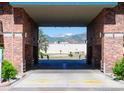 Driveway view through a brick entryway with mountains visible in the background at 3601 Arapahoe Ave # 304, Boulder, CO 80303