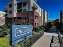 View of The Peloton with a sign and walking path showing the building's exterior and landscaping at 3601 Arapahoe Ave # 304, Boulder, CO 80303