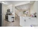 Open concept kitchen with white cabinets, stainless steel appliances and granite countertops at 504 David Ct, Platteville, CO 80651